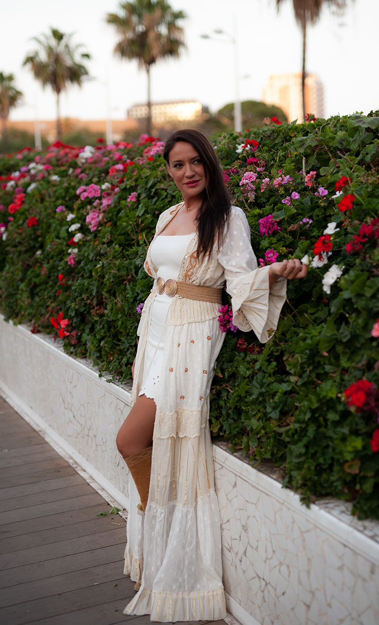 Girl in white dress among red flowers.