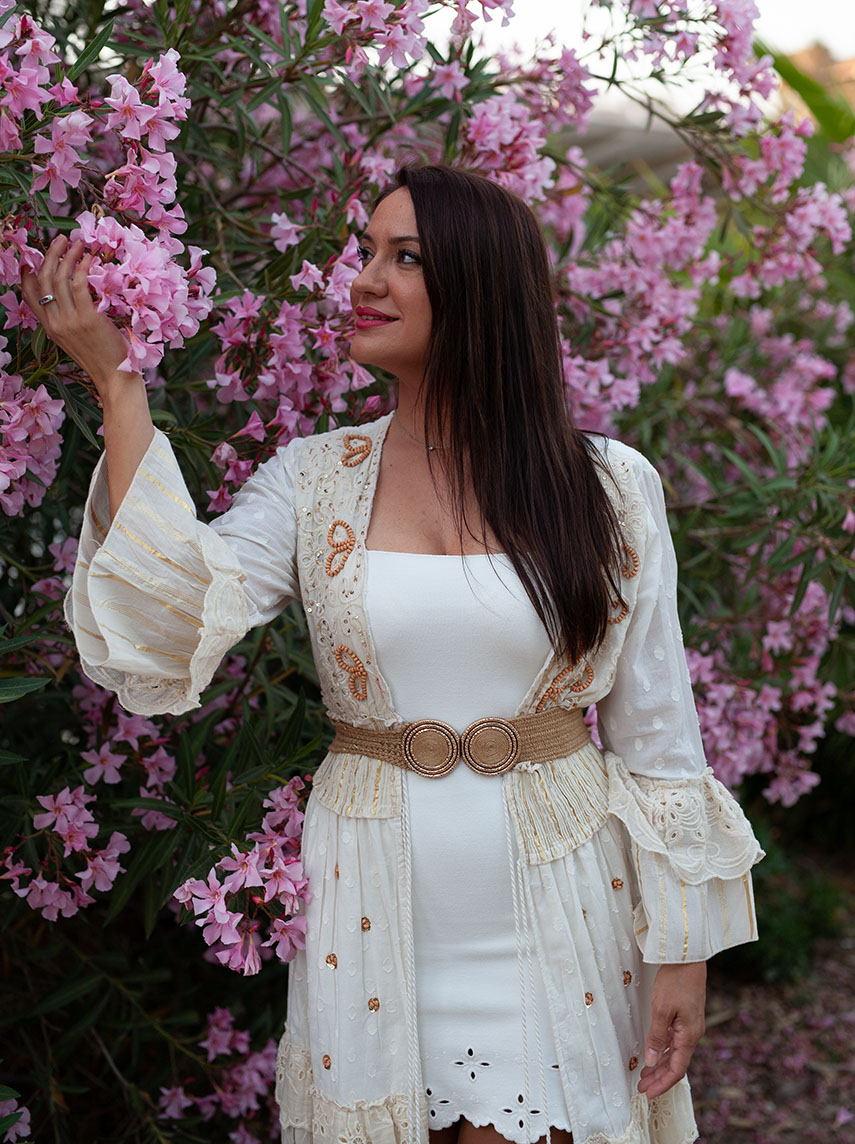 Girl in white dress among purlpe flowers.