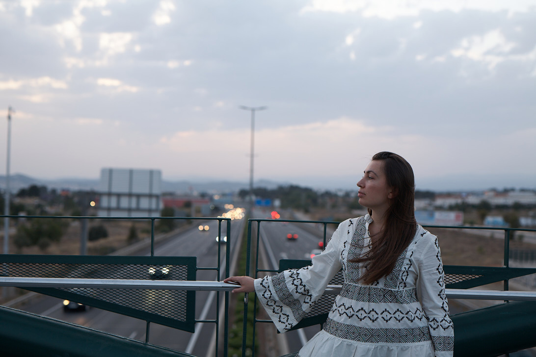 Brunette girl in white dress on the bridge