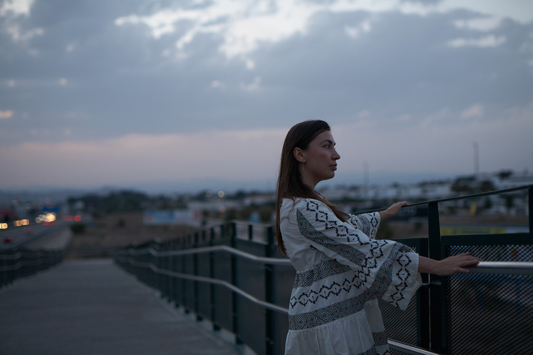 Brunette girl in white dress on the bridge